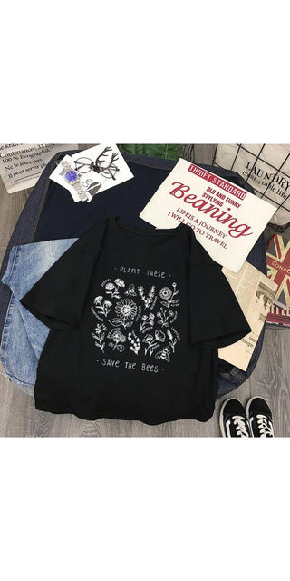 Casual black t-shirt with save the bees graphic design, books, and sneakers displayed on a table