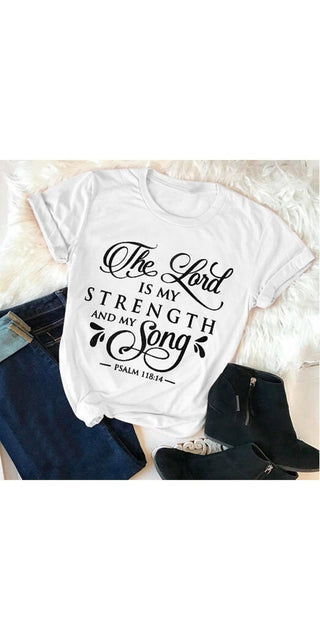 Fashionable white t-shirt with faith-based typographic design. The text reads "The Lord is my strength and my song" - a biblical quote from Psalm 118:14. The shirt features a distressed, vintage-inspired print aesthetic, complemented by a casual and relaxed style. This product is an example of trendy women's faith-based apparel that can be worn to express one's beliefs with a chic, modern touch.
