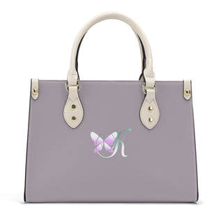 Stylish grey and white leather handbag with elegant butterfly logo design. Structured shape with dual top handles and silver-tone hardware. Versatile and fashionable accessory from the K-AROLE women's fashion brand.
