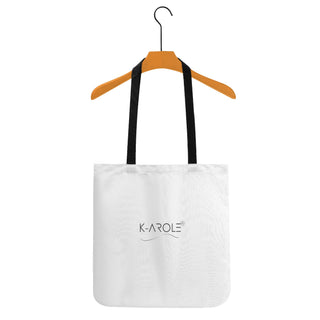 Stylish white cotton tote bag with K-AROLE brand logo, hanging on wooden clothing hanger against white background.