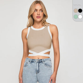 Chic cropped beige top with contrasting white trim and cutout details, worn with light-wash denim jeans against a white background.