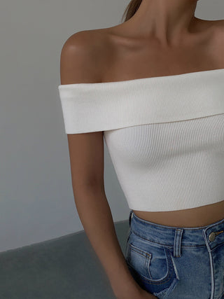 Sleek white off-shoulder knit crop top on a female model against a neutral background