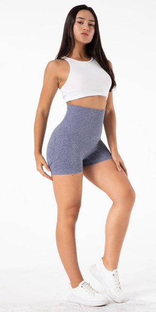 Chic yoga attire: white racerback top, gray shorts, and stylish white sneakers. A trendy, comfortable outfit perfect for yoga or activewear. The image showcases the versatile and fashionable nature of the product.