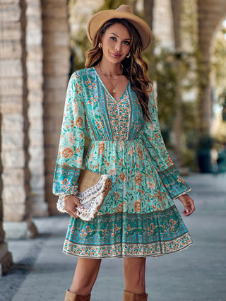Elegant floral printed dress with cinched waist and ruffled sleeves, styled with a wide-brimmed hat for a chic boho look.