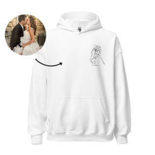 A white hooded sweatshirt with a minimalist graphic design of two embracing figures printed on the front, against a plain white backdrop.