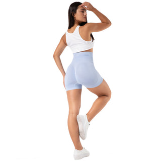 Comfortable high-waist seamless yoga shorts worn by a woman with long dark hair, standing against a white background.