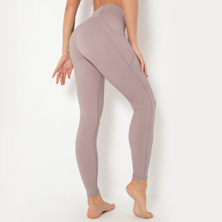 Form-fitting beige yoga pants with an athletic, high-waisted design showcasing the model's toned physique.