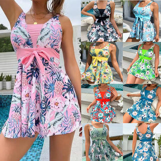 Vibrant floral printed women's summer dress. The image shows a collection of brightly colored, floral patterned mini dresses in various styles, including v-neck and sleeveless cuts. The dresses feature tropical leaf and flower motifs in a range of hues like pink, blue, yellow, and green. The dresses appear to be fashionable, breezy, and suitable for warm weather occasions.