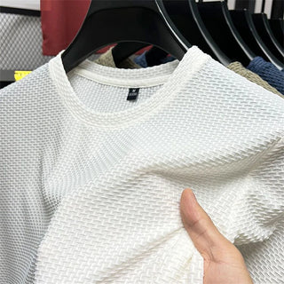 White knit summer mesh t-shirt with round neck displayed on clothing rack at K-AROLE store. The lightweight, breathable fabric and casual style make this top a versatile choice for warm weather.