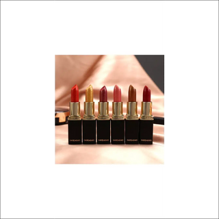 Metallic lipstick collection with temperature-changing shades and a shiny gilt finish, showcased on a reflective surface.