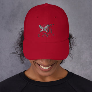 Red dad hat with K-AROLE logo and butterfly design, worn by a smiling person