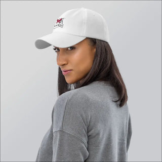 White K-AROLE dad hat with a logo worn by a woman with long dark hair in a gray top