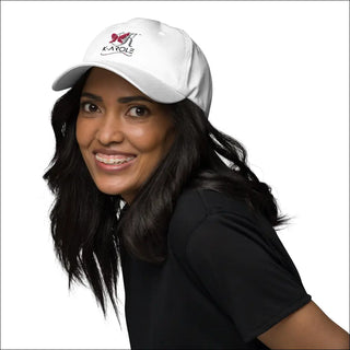 White adjustable dad hat with K-AROLE logo worn by a smiling woman with long dark hair