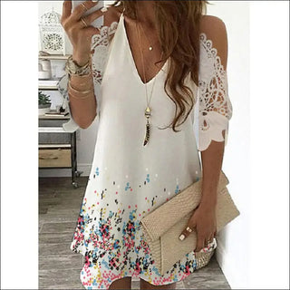 Elegant white dress with floral print and lace sleeves, stylish gold necklace, fashionable accessories, attractive young woman in modern, trendy attire.