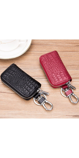 Premium leather key holder in black and red. Compact wallet-style pouch with zipper closure to securely organize and carry car keys, key fobs, or other small items. Stylish and practical accessory for everyday use.