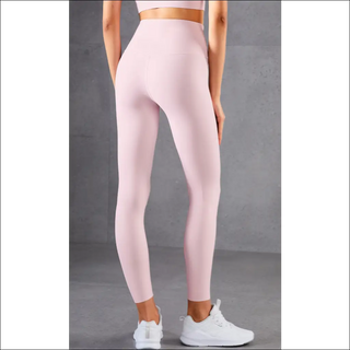 High-waisted pink skinny fitness leggings with a solid color design, worn by a female model against a neutral gray background.