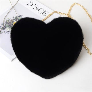 Luxurious black heart-shaped furry shoulder bag with a golden chain strap, set against a white background with decorative flowers.