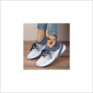 Breathable mesh sports shoes for women. Stylish, casual sneakers with lace-up closure for a secure fit. Neutral color scheme complements various outfits. Ideal for daily activities like walking or running.