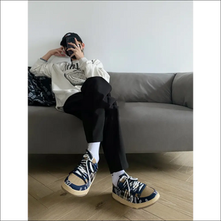 Stylish fitness sneakers with bold zebra print design on a person relaxing on a grey sofa