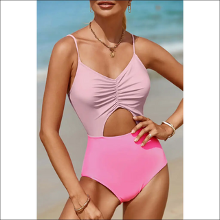 Chic pastel pink one-piece swimwear with spaghetti straps, ruching, and cutout detail. Paired with gold statement necklace for a trendy beach look.